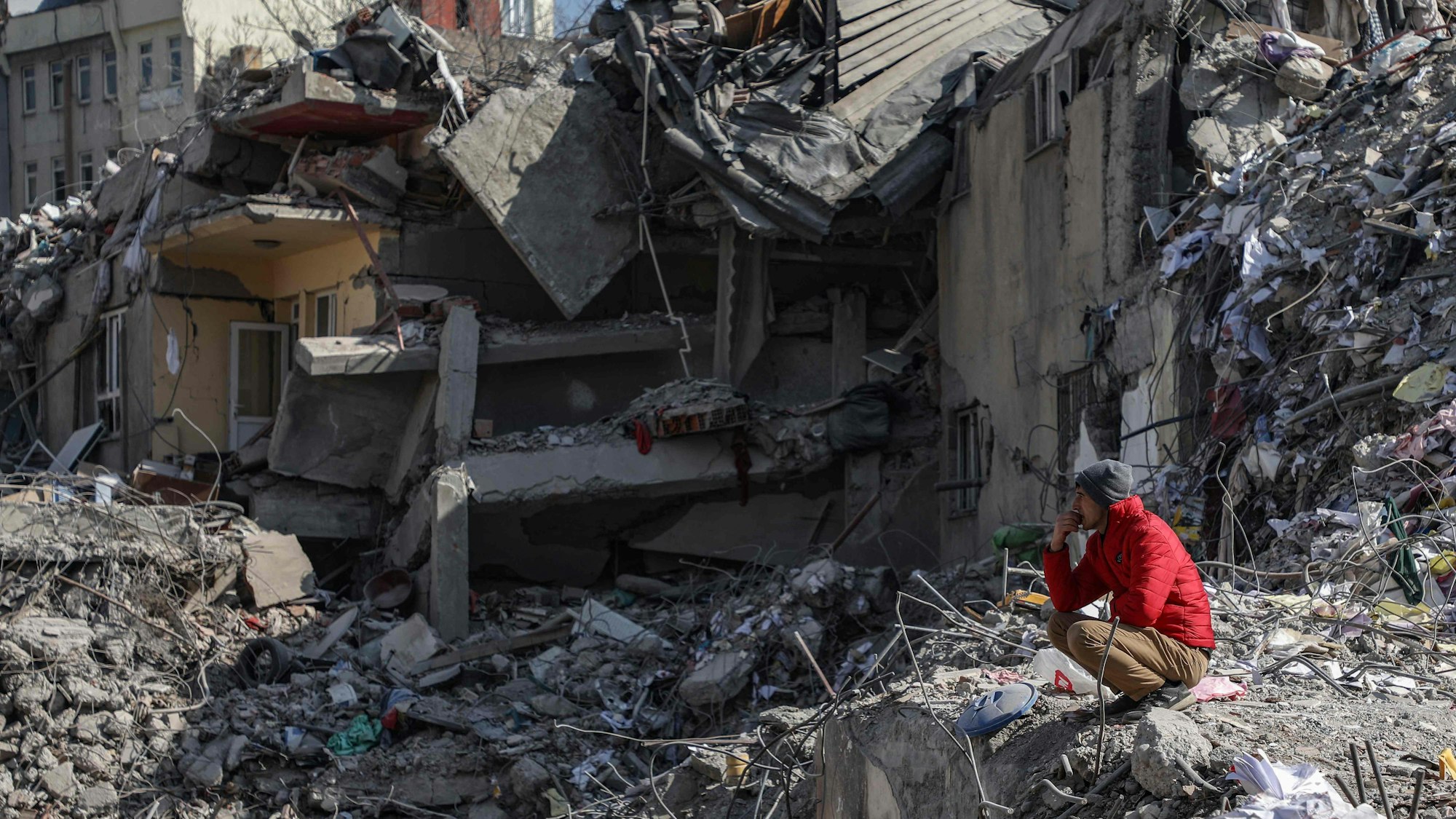 Ein Mann schaut auf die Trümmer eines von Erdbeben zerstörten Gebäudes in Kahramanmaras in der Türkei.