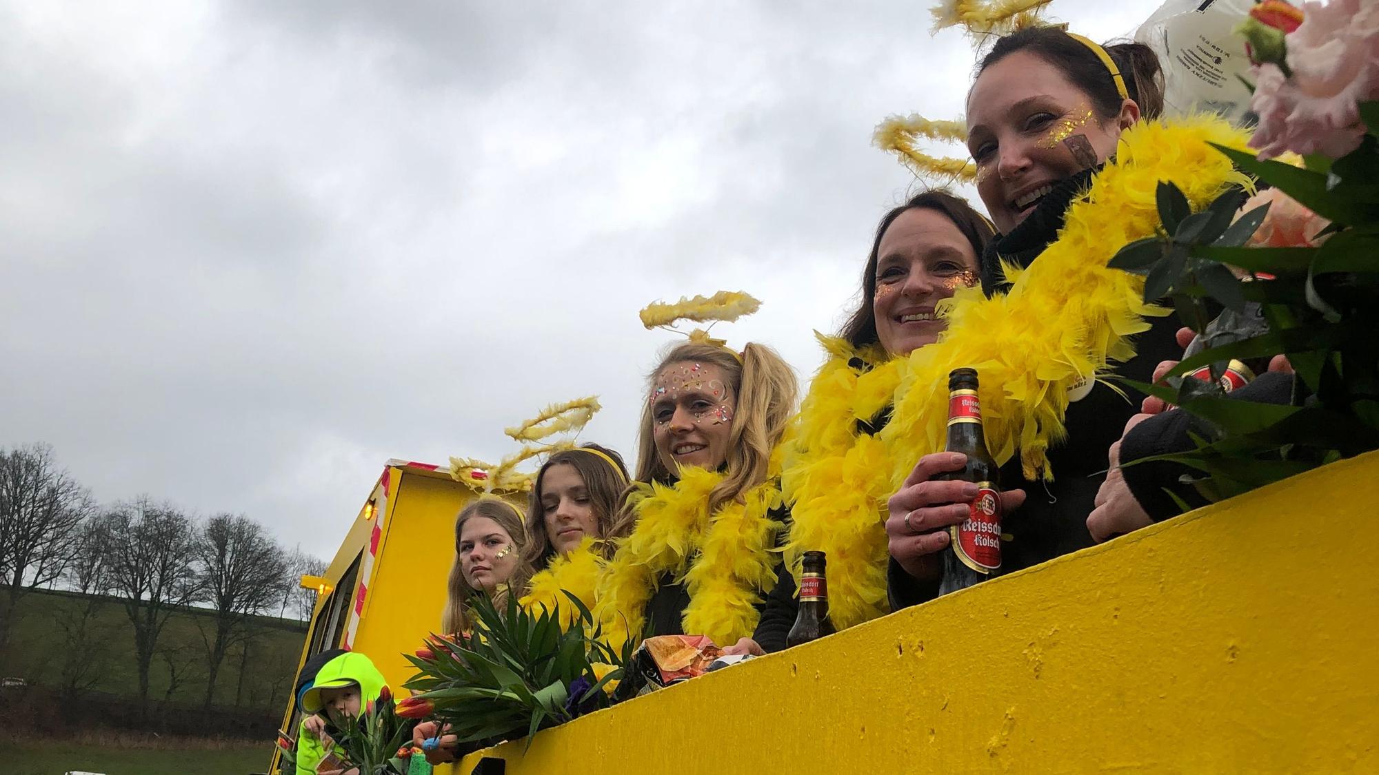 Fünf verkleidete Frauen stehen auf ihrem Wagen.