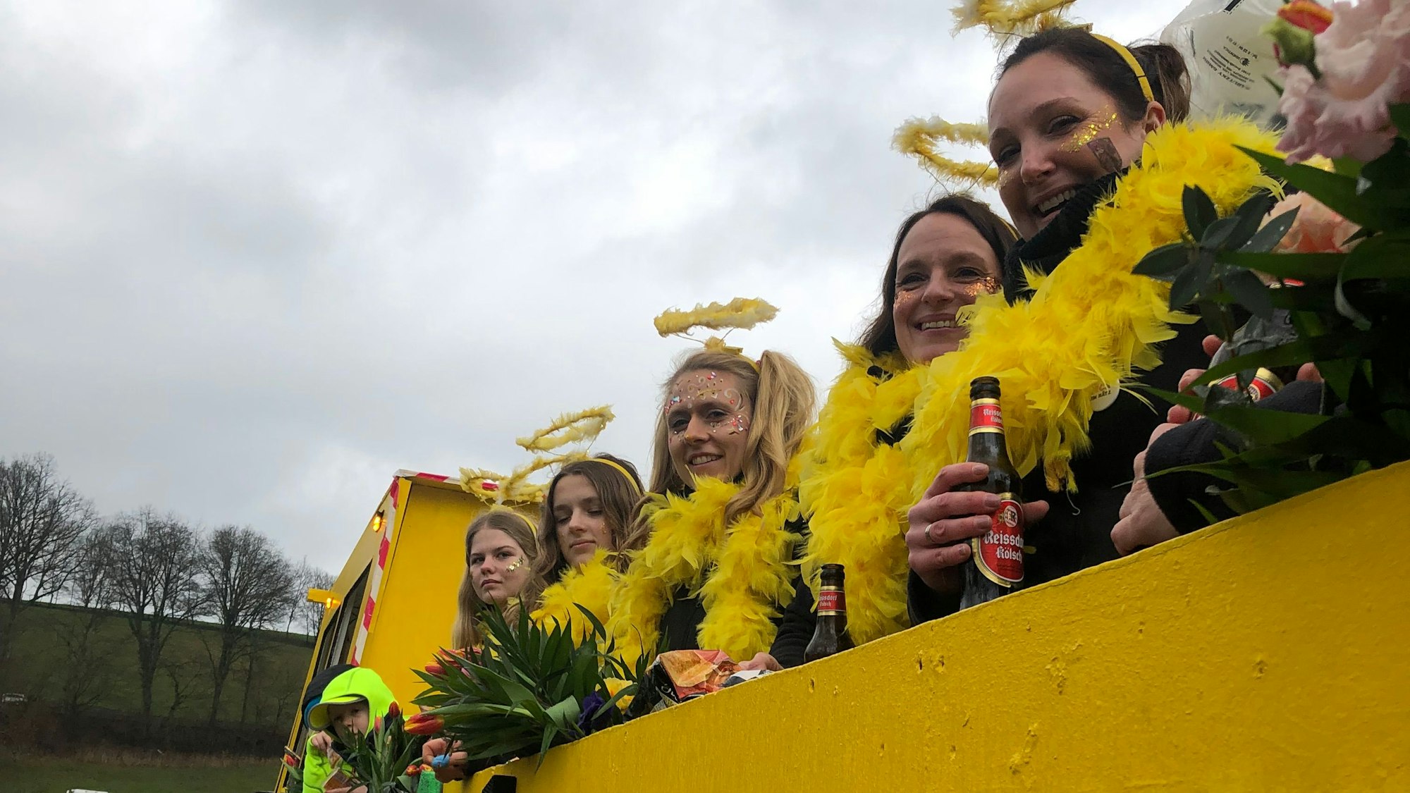 Fünf verkleidete Frauen stehen auf ihrem Wagen.