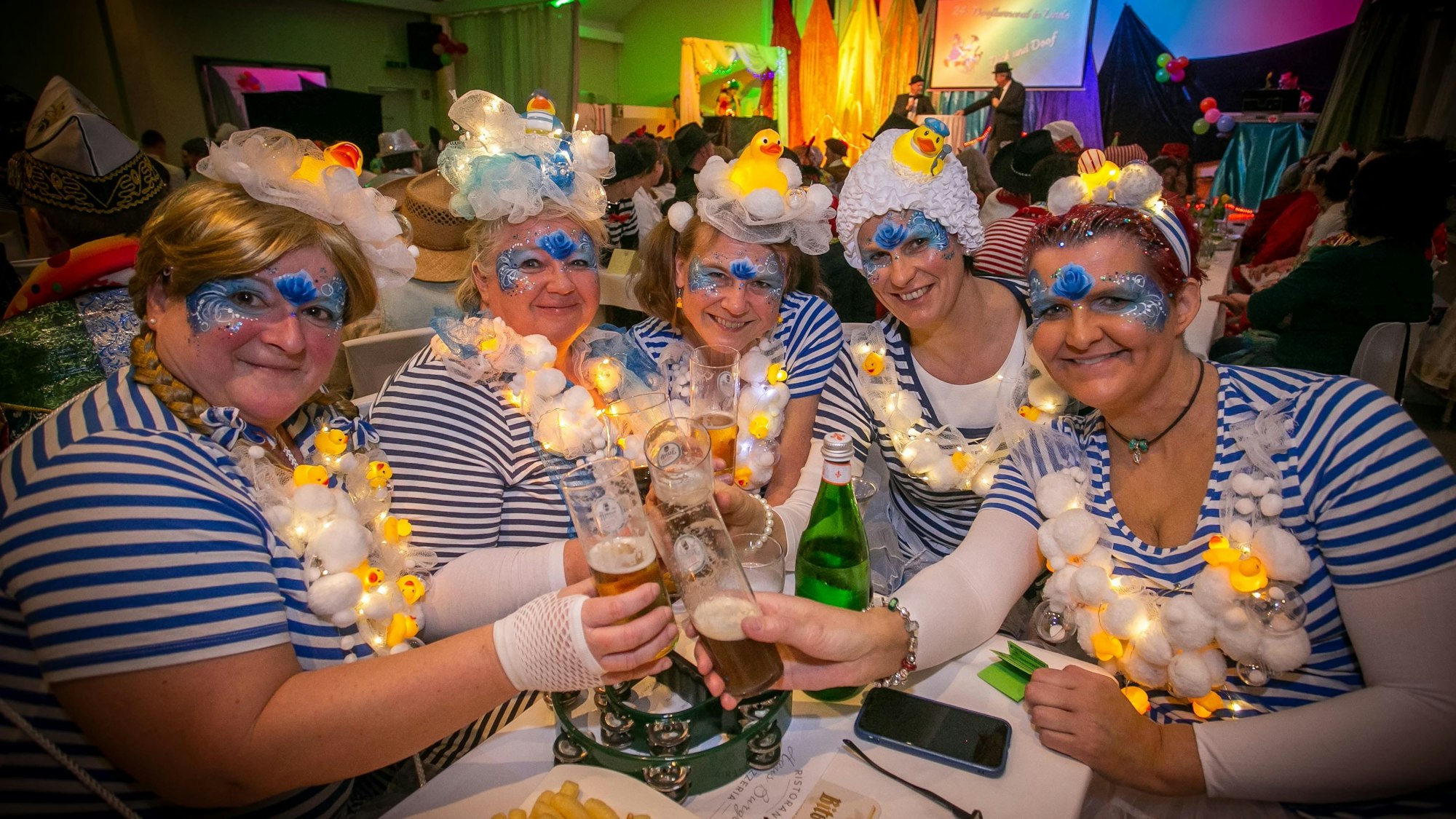 Fünf verkleidete Frauen stoßen mit Biergläsern an.