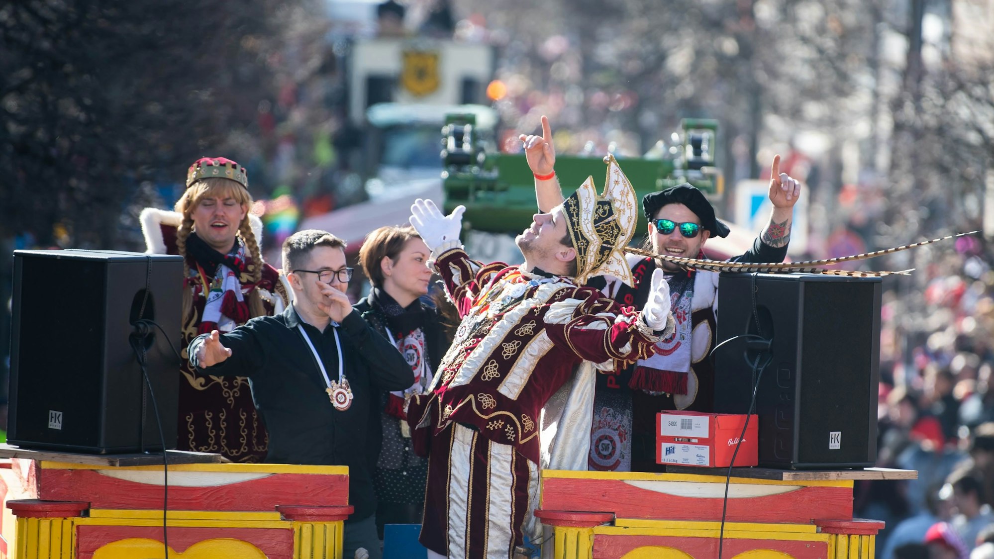 Tollitäten aus Frauenberg feiern auf einem Wagen bei Rosenmontagszug in Euskirchen.