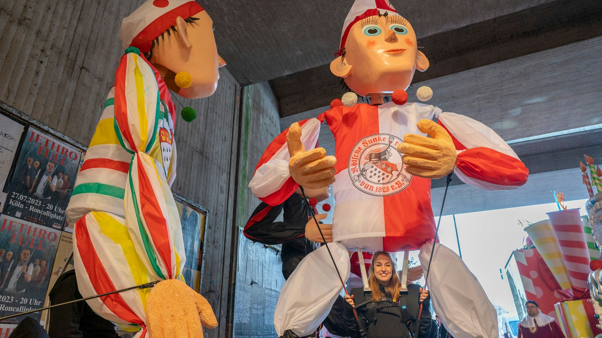 Nele Hofmann ist klein unter der Großfigur zu sehen. Das Foto ist unter einer Brücke aufgenommen, an den Wänden und der Decke ist Beton zu sehen.