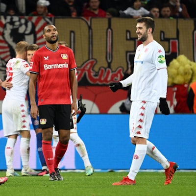 19.02.2023, Nordrhein-Westfalen, Leverkusen: Fußball: Bundesliga, Bayer Leverkusen - FSV Mainz 05, 21. Spieltag, in der BayArena: Leverkusens Jonathan Tah (M) steht nach dem Spiel auf dem Platz, während die Mainzer ihren 2:3-Auswärtssieg feiern. Foto: Federico Gambarini/dpa - WICHTIGER HINWEIS: Gemäß den Vorgaben der DFL Deutsche Fußball Liga bzw. des DFB Deutscher Fußball-Bund ist es untersagt, in dem Stadion und/oder vom Spiel angefertigte Fotoaufnahmen in Form von Sequenzbildern und/oder videoähnlichen Fotostrecken zu verwerten bzw. verwerten zu lassen. +++ dpa-Bildfunk +++