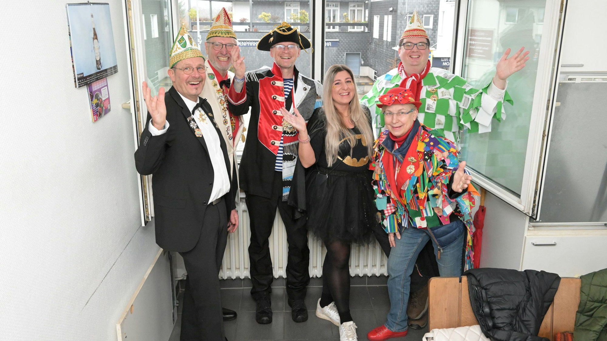 Die sechsköpfige Jury steht kostümiert vor dem Fenster.