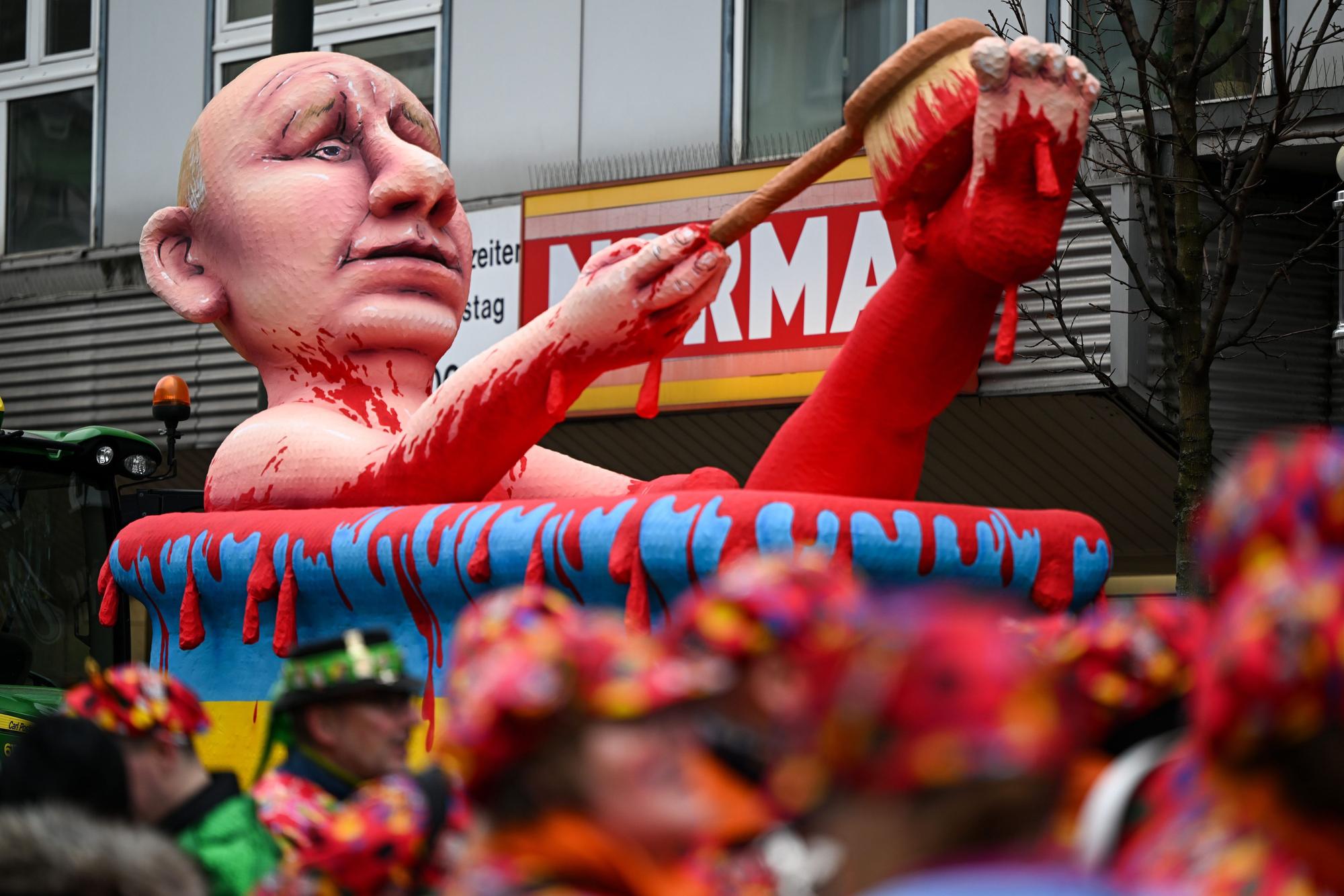 Ein Mottowagen zeigt den russischen Präsidenten Putin, der in einer Badewanne in den ukrainischen Nationalfarben ein Blutbad nimmt.