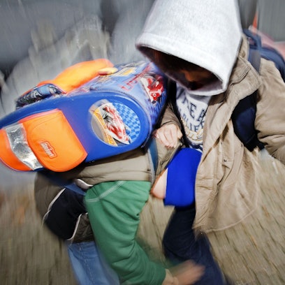 Zwei Kinder prügeln sich auf einem Schulhof.