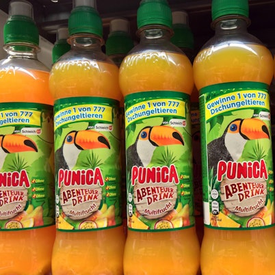 Mehrere Punica-Flaschen mit der Aufschrift „Punica Abenteuer-Drink“ sind in einem Supermarkt-Regal zu sehen.