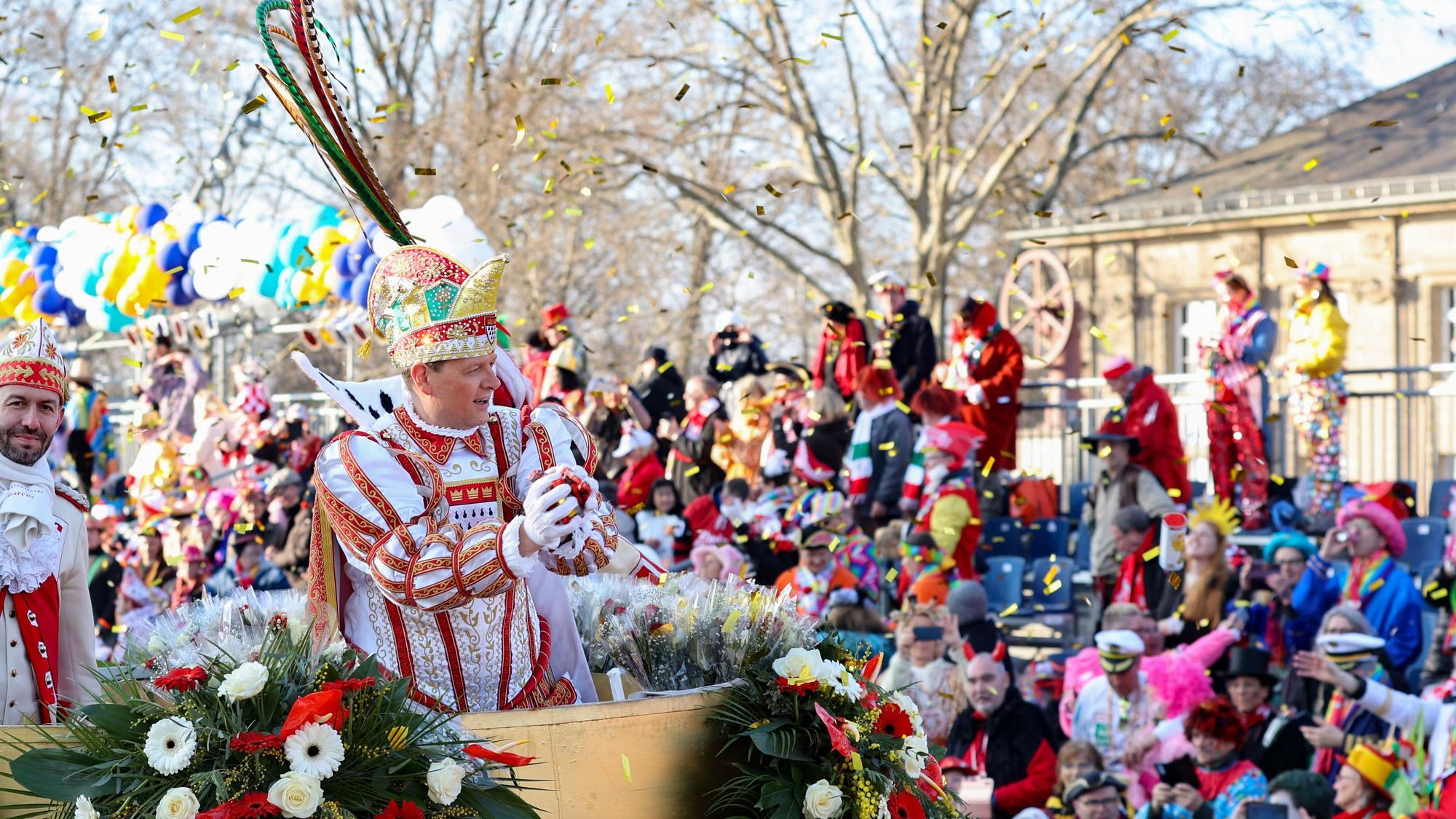 Prinz Boris wirft im Rosenmontagszug eine Handvoll Kamelle auf die kostümierte Menge vor dem Deutzer Bahnhof (Bild von 2023).