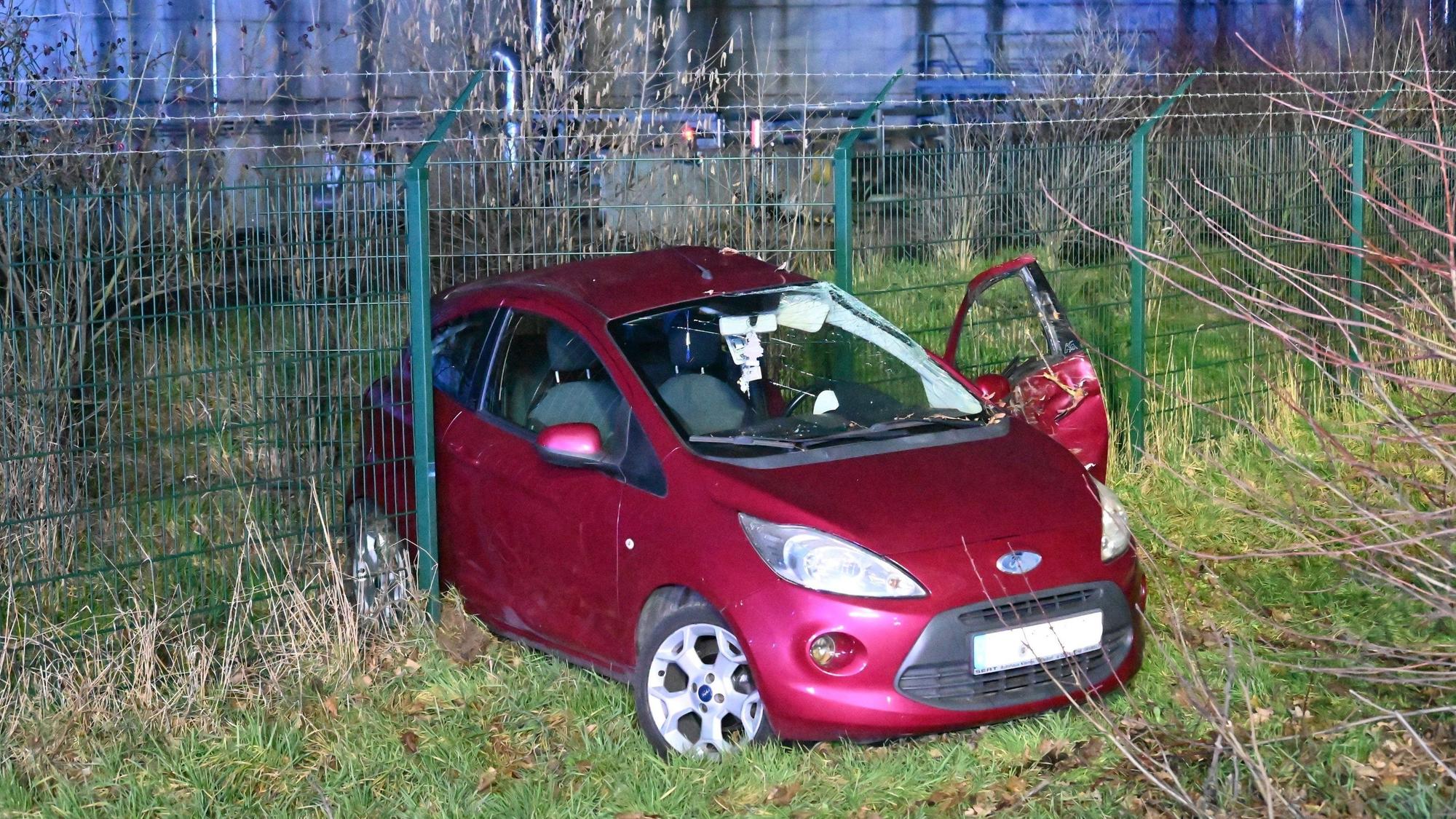 Ein roter Kleinwagen ist bei einem Unfall in den Zaun der Biogas-Anlage in Bergheim-Paffendorf gerutscht.
