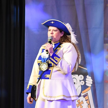 Monica Molitor auf einer Bühne im Kostüm der Blau-Wiesse Funke Wahn.