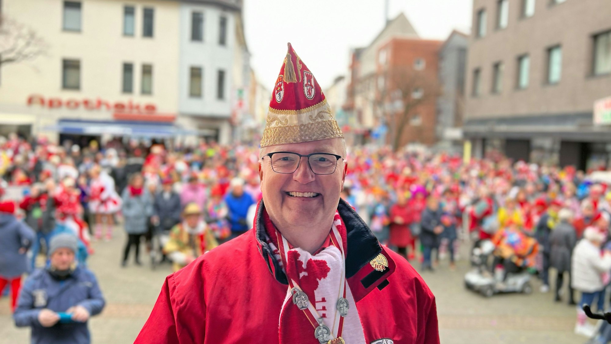 Stephan Demmer bei der Eröffnung des Straßenkarnevals in der Porzer Innenstadt mit den Jecken im Hintergrund.