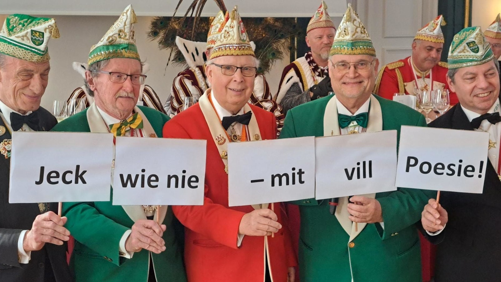 Die Karnevalisten halten das Motto mit Schildern hoch.