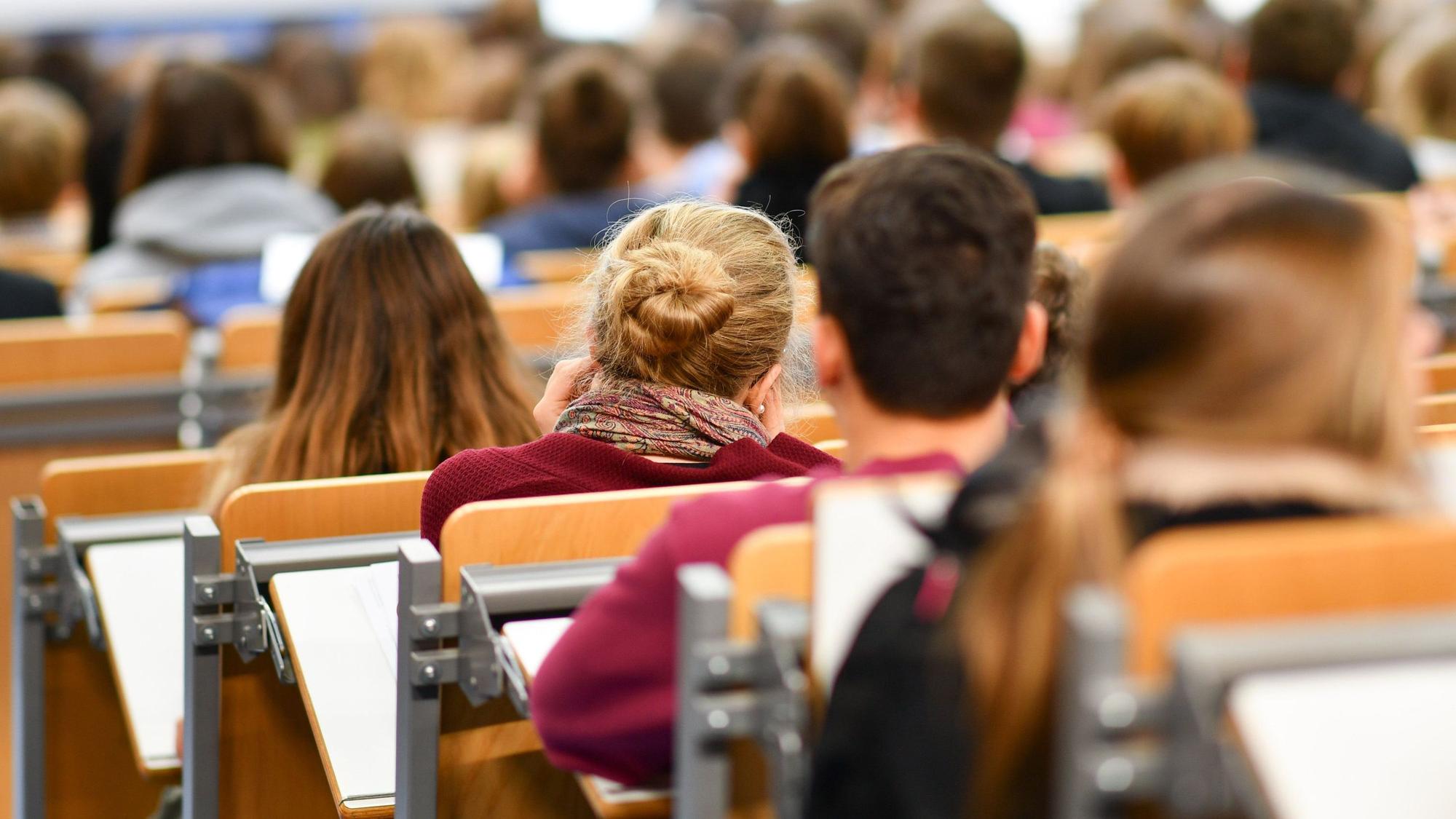 Studenten sitzen bei der Begrüßung der Erstsemester in einem Hörsaal.