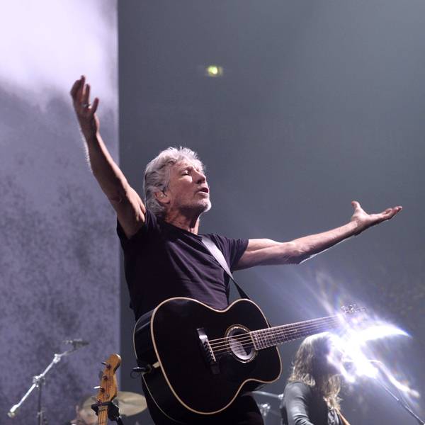 Das Bild zeigt den Musiker Rogr Waters mit einer Gitarre auf einer Bühne.
