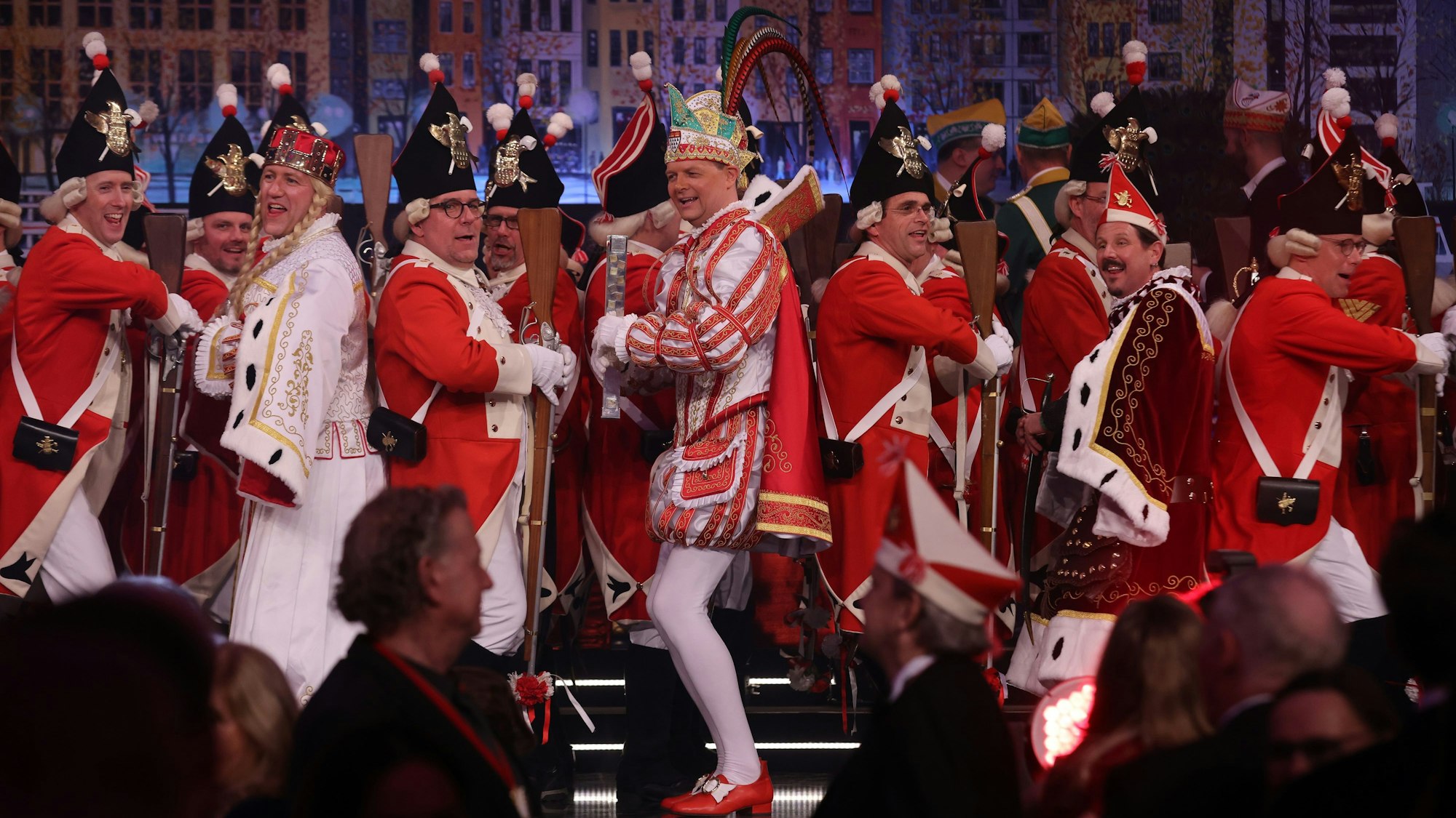 Mehrere Mitglieder der Roten Funken tanzen auf der Bühne mit Prinz Boris I. (Boris Müller), Bauer Marco (Marco Schneefeld) und Jungfrau Agrippina (André Fahnenbruck) im Gürzenich in Köln.