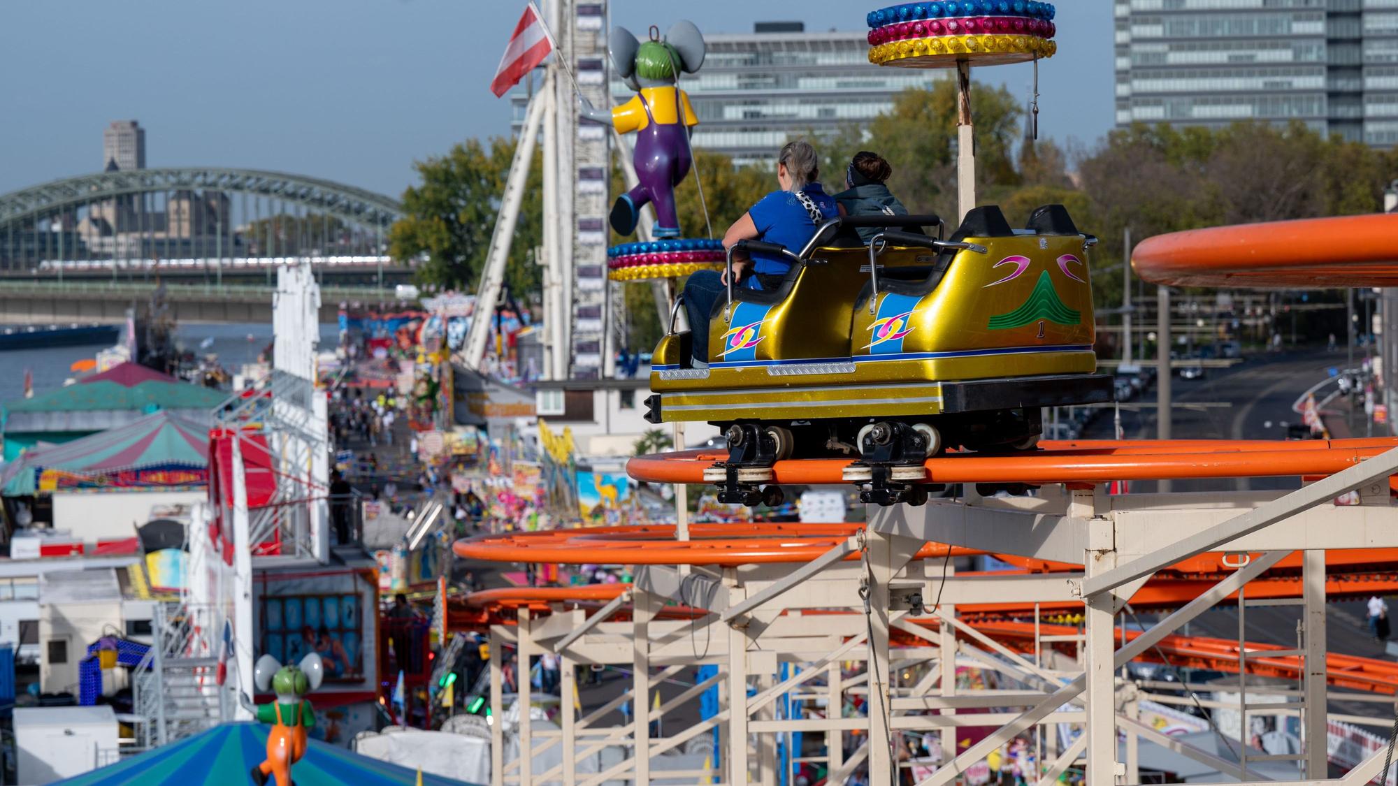 Eine Achterbahn auf der Deutzer Herbstkirmes mit zwei fahrenden Personen.