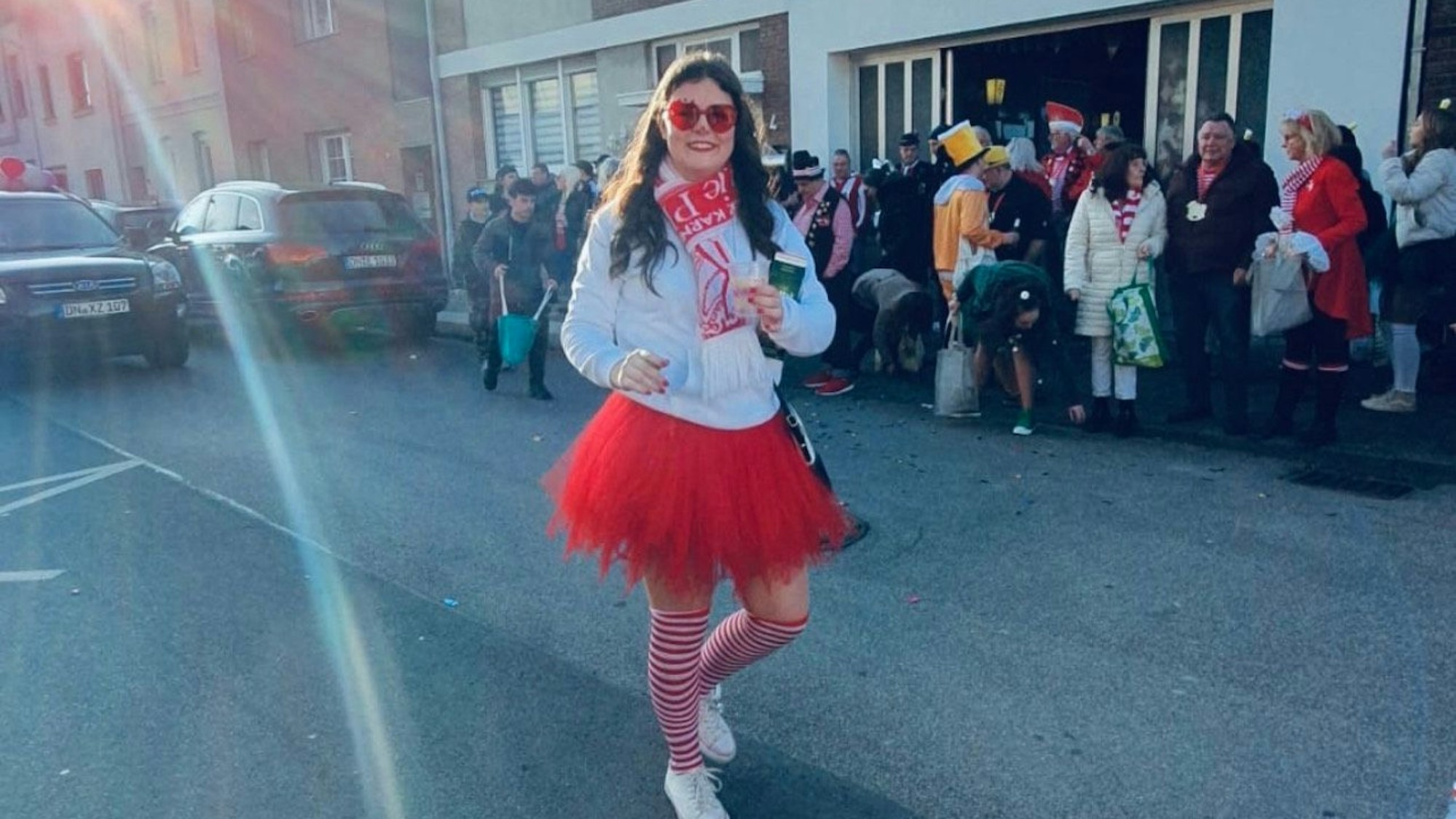 Eine junge Frau im Karnevalskostüm geht über eine Straße.