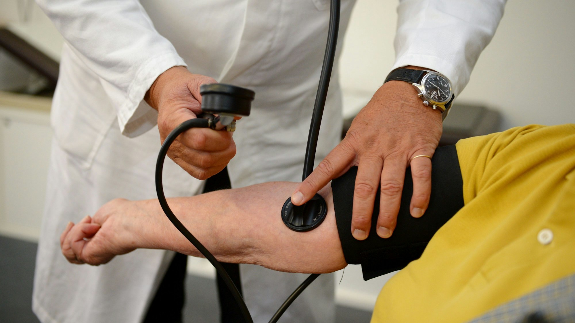 Ein Hausarzt misst in seiner Praxis einer Patientin den Blutdruck. (Symbolbild)