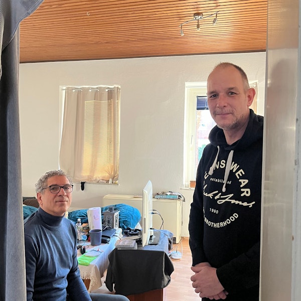 Rolf Bergheim (r.) steht in der Tür zu seinem Wohnzimmer, sitzend links ist sein Vermieter Nikos Kapourakis zu sehen.