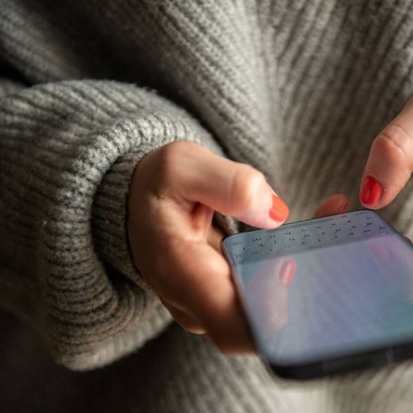 Eine Frau tippt auf ihrem Smartphone.