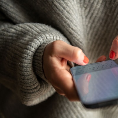 Eine Frau tippt auf ihrem Smartphone.