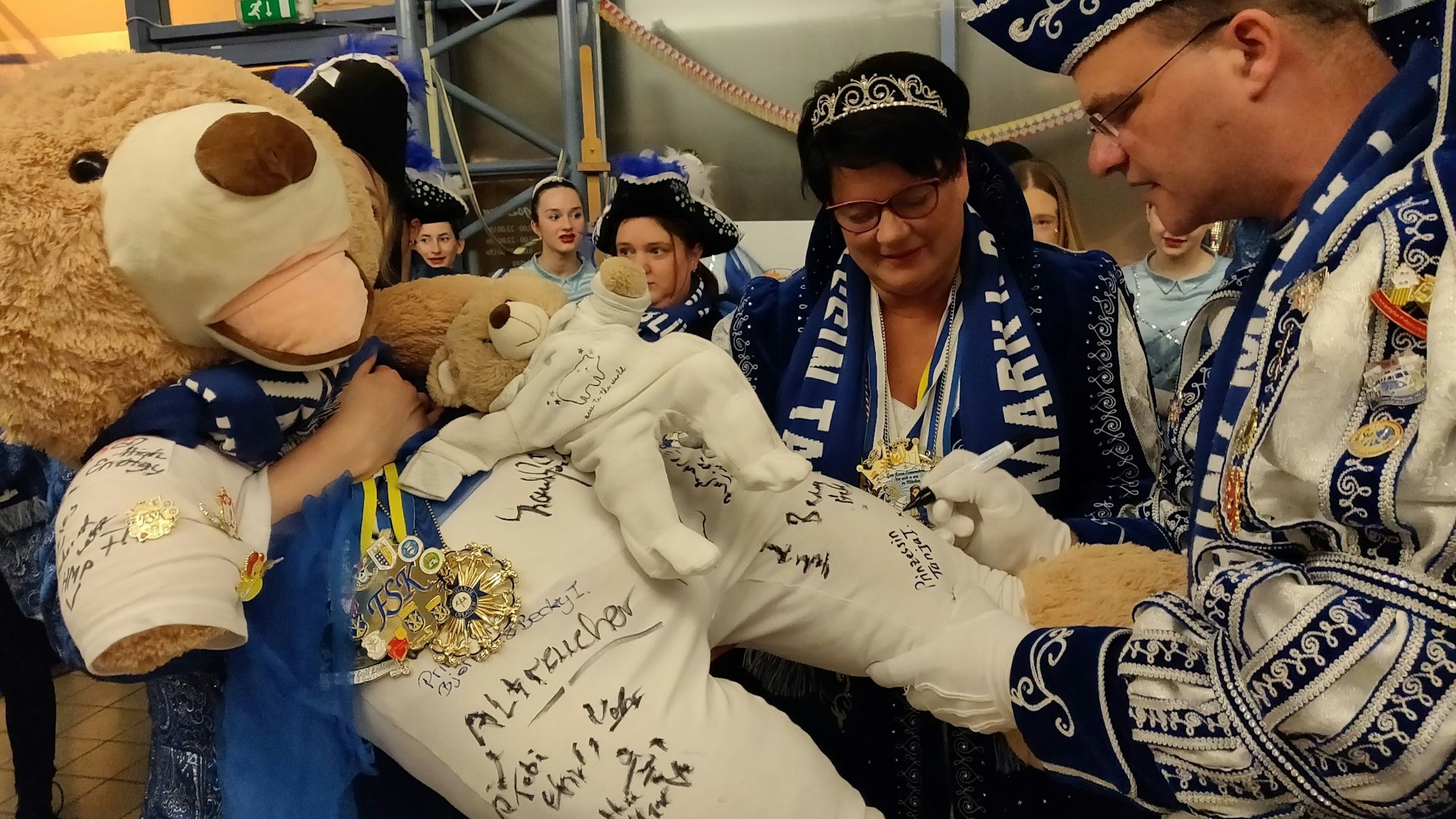 Prinzenpaar Mark und Tanja signieren den mit Spendenbär