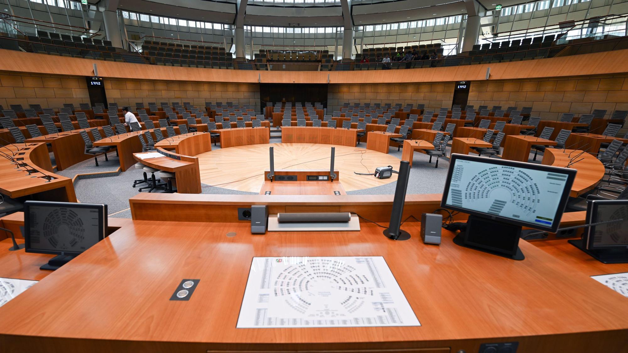Zu sehen ist der Plenarsaal im nordrhein-westfälischen Landtag.Die Sitze sind leer, zentral steht ein Rednerpult.
