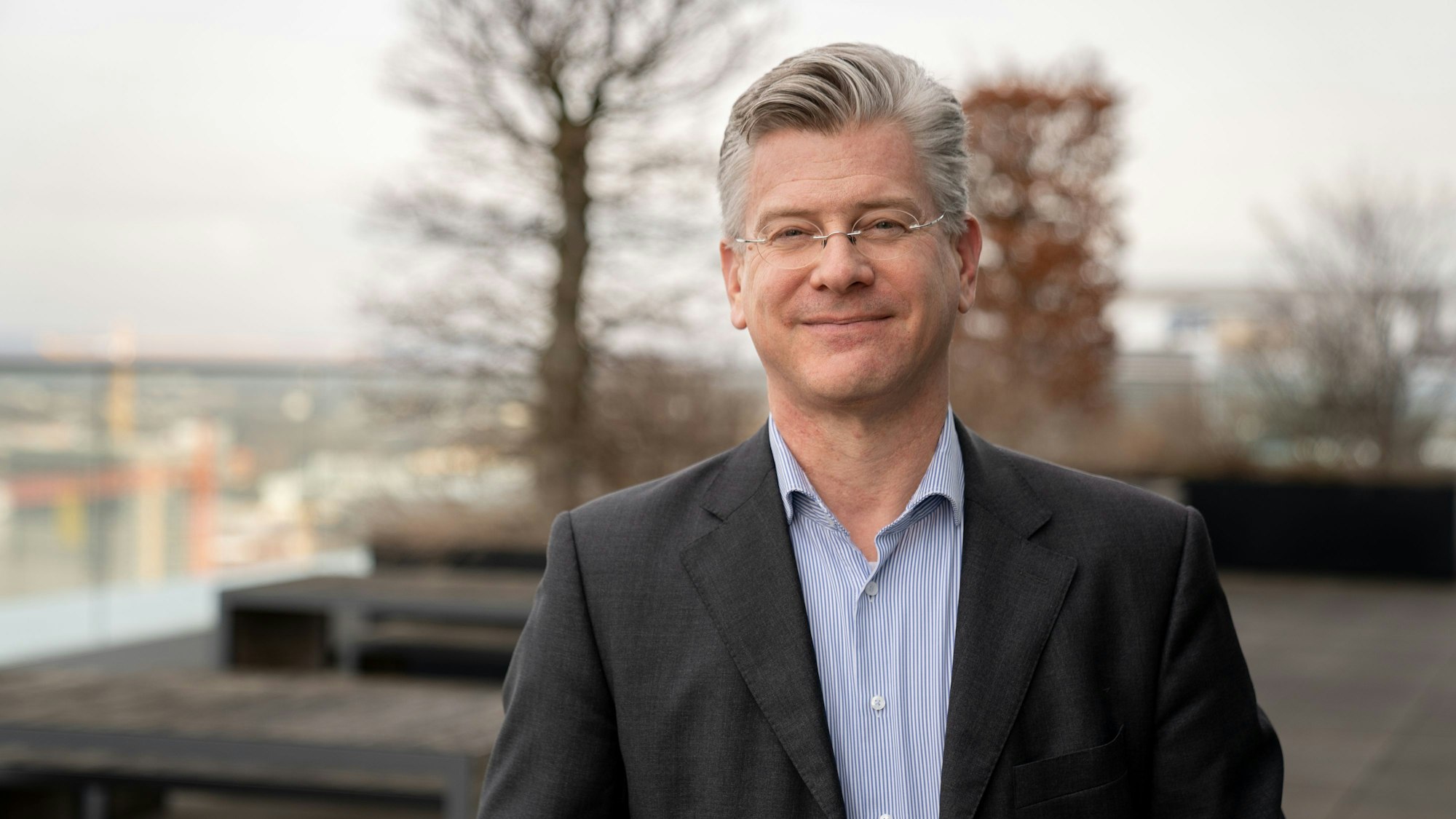 Ein älterer Herr auf einer Terrasse.