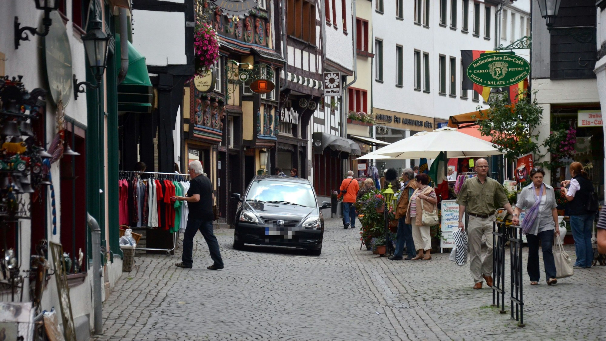 Ein Auto fährt im Jahr 2012 über die Orchheimer Straße in Bad Münstereifel, auf der auch Passanten schlendern.
