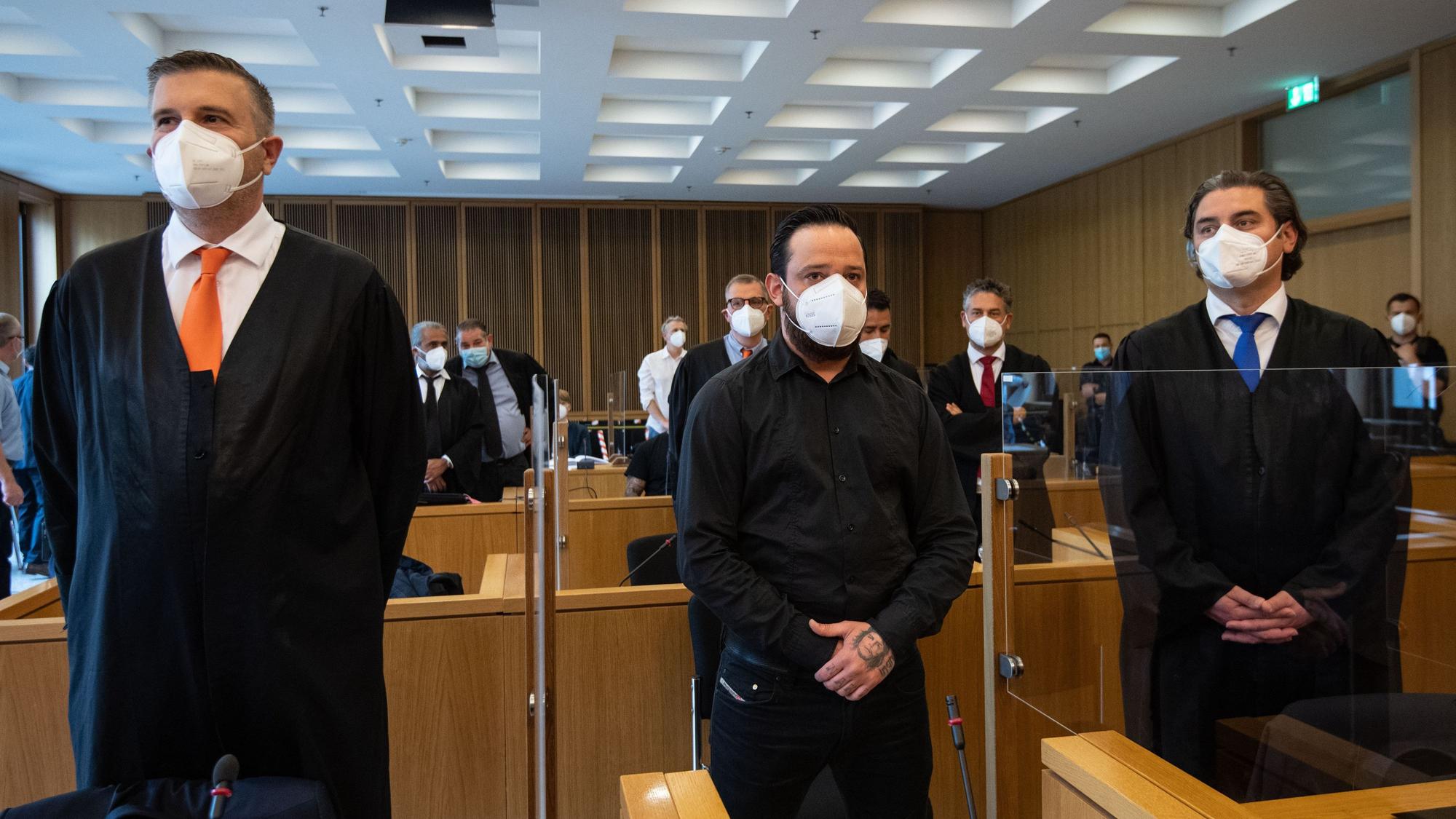 Der ehemalige Bundesligaprofi Deniz Naki (M) steht im Landgericht hinter der Anklagebank. Vor dem Landgericht Aachen hat am Freitag ein Prozess gegen Naki wegen Bildung einer kriminellen Vereinigung begonnen. Zusammen mit dem 31 Jahre alten Deutschen sind drei weitere Männer türkischer Staatsangehörigkeit angeklagt. Ihnen wird unter anderem Drogenhandel, Erpressung und gefährliche Körperverletzung vorgeworfen.