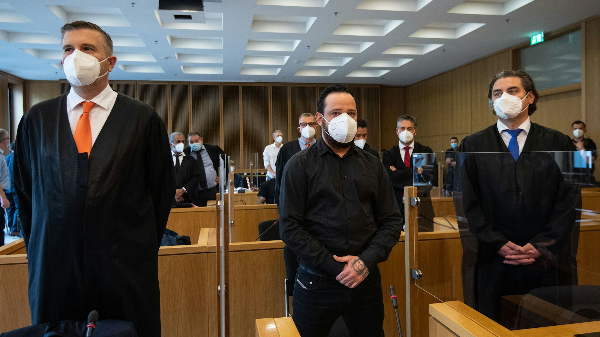 Der ehemalige Bundesligaprofi Deniz Naki (M) steht im Landgericht hinter der Anklagebank. Vor dem Landgericht Aachen hat am Freitag ein Prozess gegen Naki wegen Bildung einer kriminellen Vereinigung begonnen. Zusammen mit dem 31 Jahre alten Deutschen sind drei weitere Männer türkischer Staatsangehörigkeit angeklagt. Ihnen wird unter anderem Drogenhandel, Erpressung und gefährliche Körperverletzung vorgeworfen.