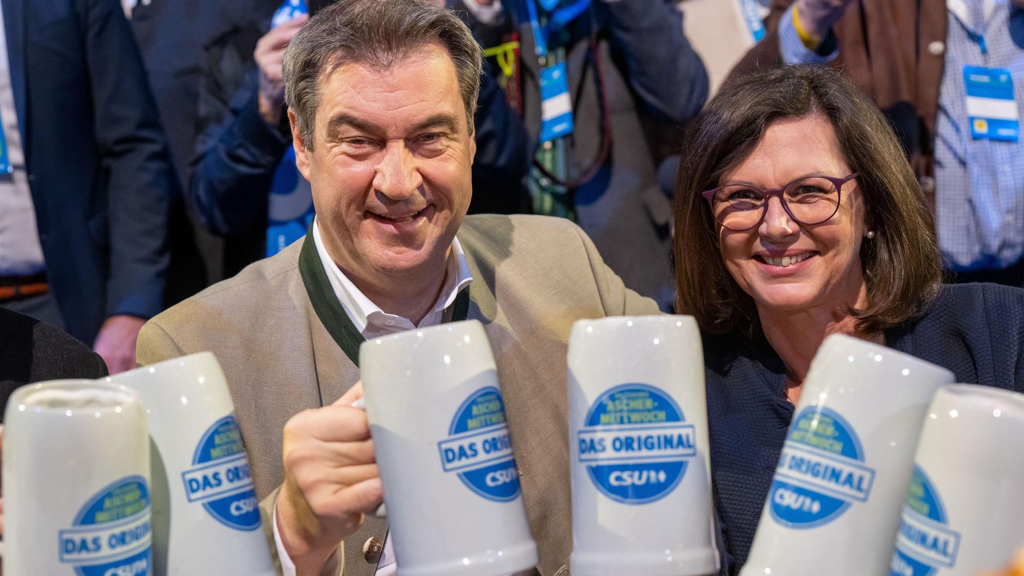 Der CSU-Vorsitzende und bayerische Ministerpräsident Markus Söder prostet mit Bier beim Politischen Aschermittwoch der CSU in der Dreiländerhalle Passau in Richtung Kamera. Rechts Ilse Aigner (CSU), Präsidentin des Bayerischen Landtags.