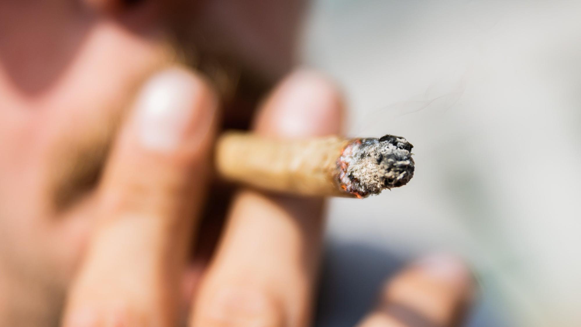 Ein Mann raucht einen Joint.