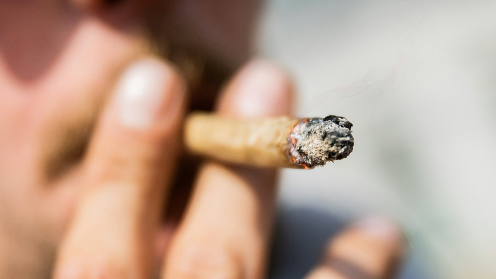 Ein Mann raucht einen Joint.