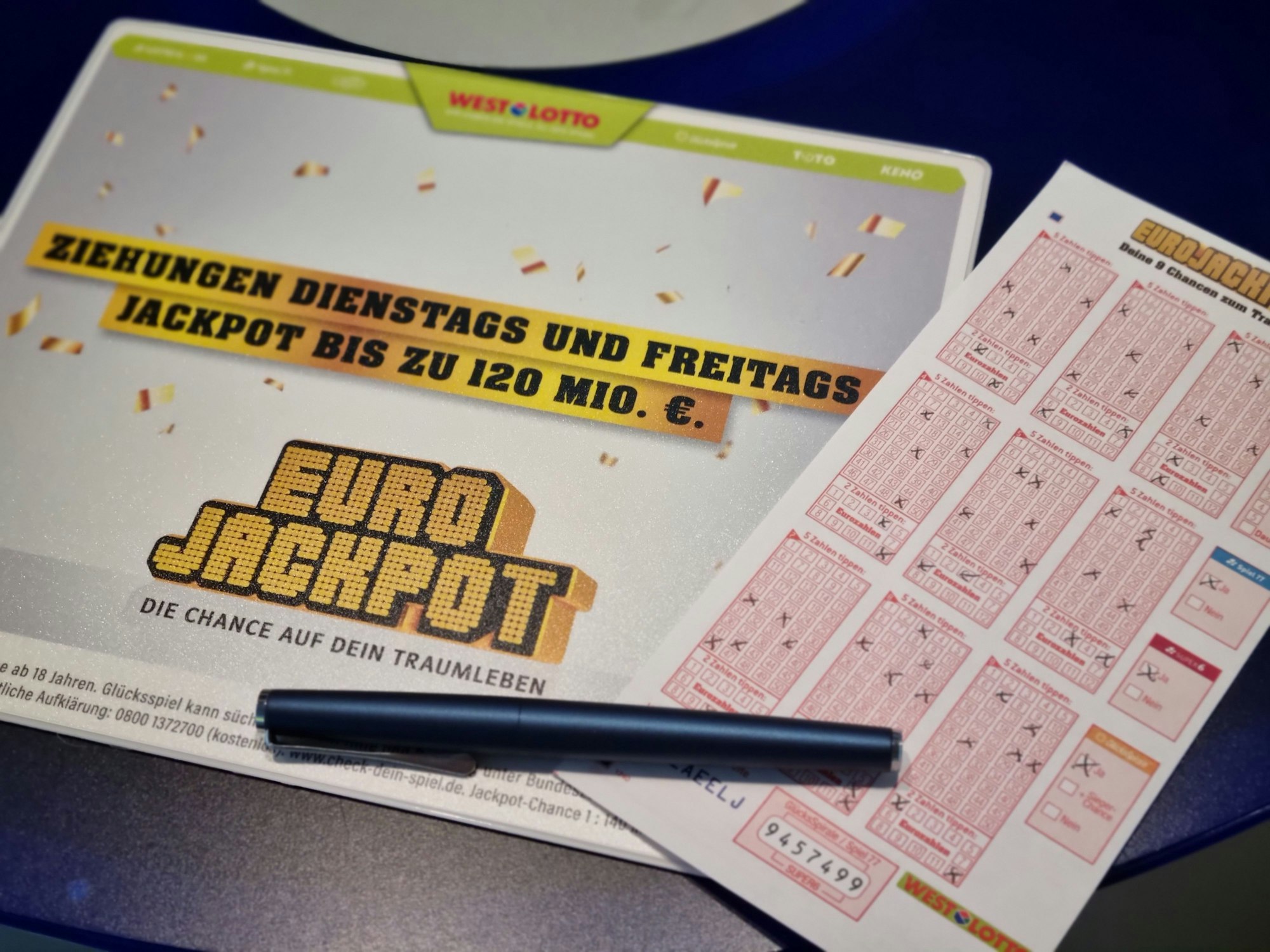 Ausgefüllter Eurojackpot Tippschein liegt auf einer Eurojackpot Schreibunterlage.