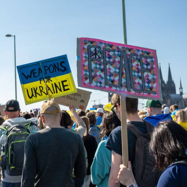 Auf Plakaten fordern Demonstranten Waffen und Frieden.