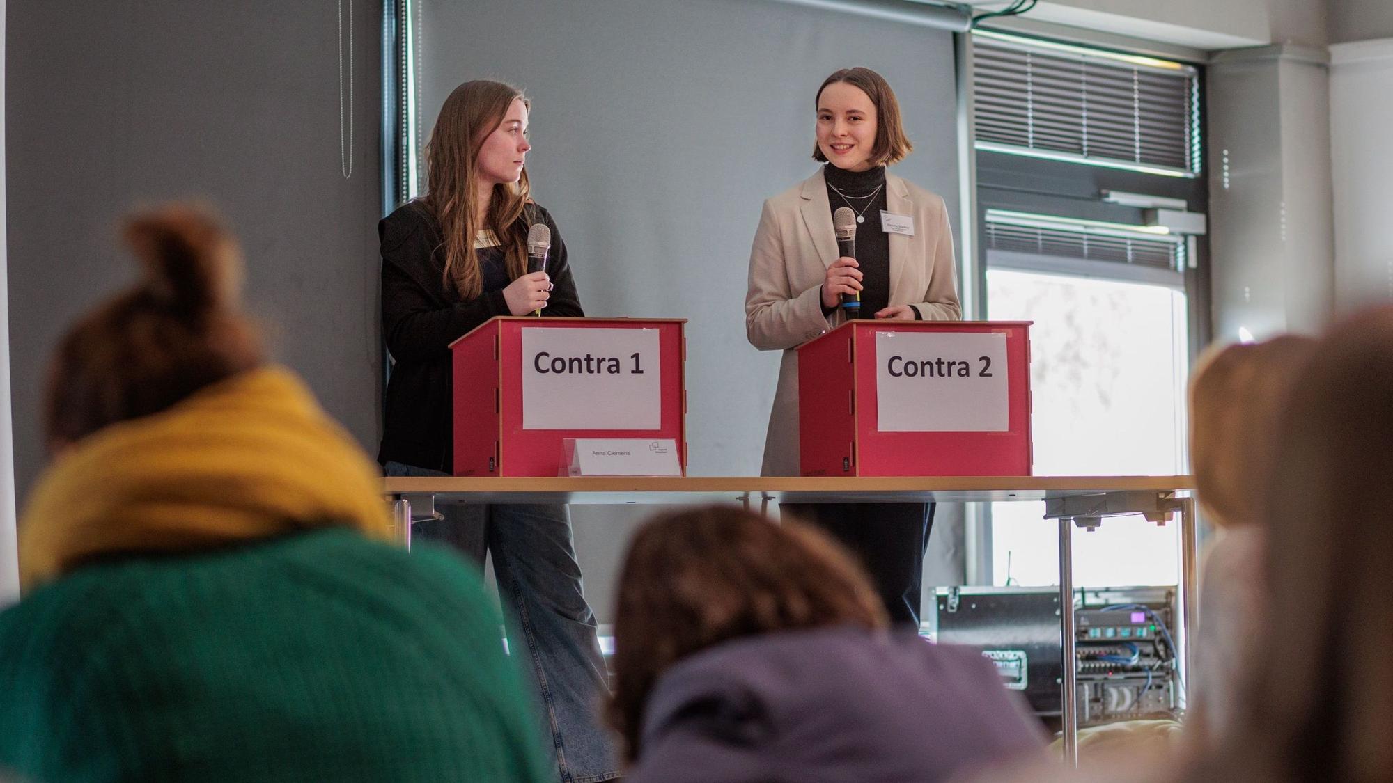 Victoria Guenther und ihre Gegnerin Anna Clemens stehen an Rednerpulten.