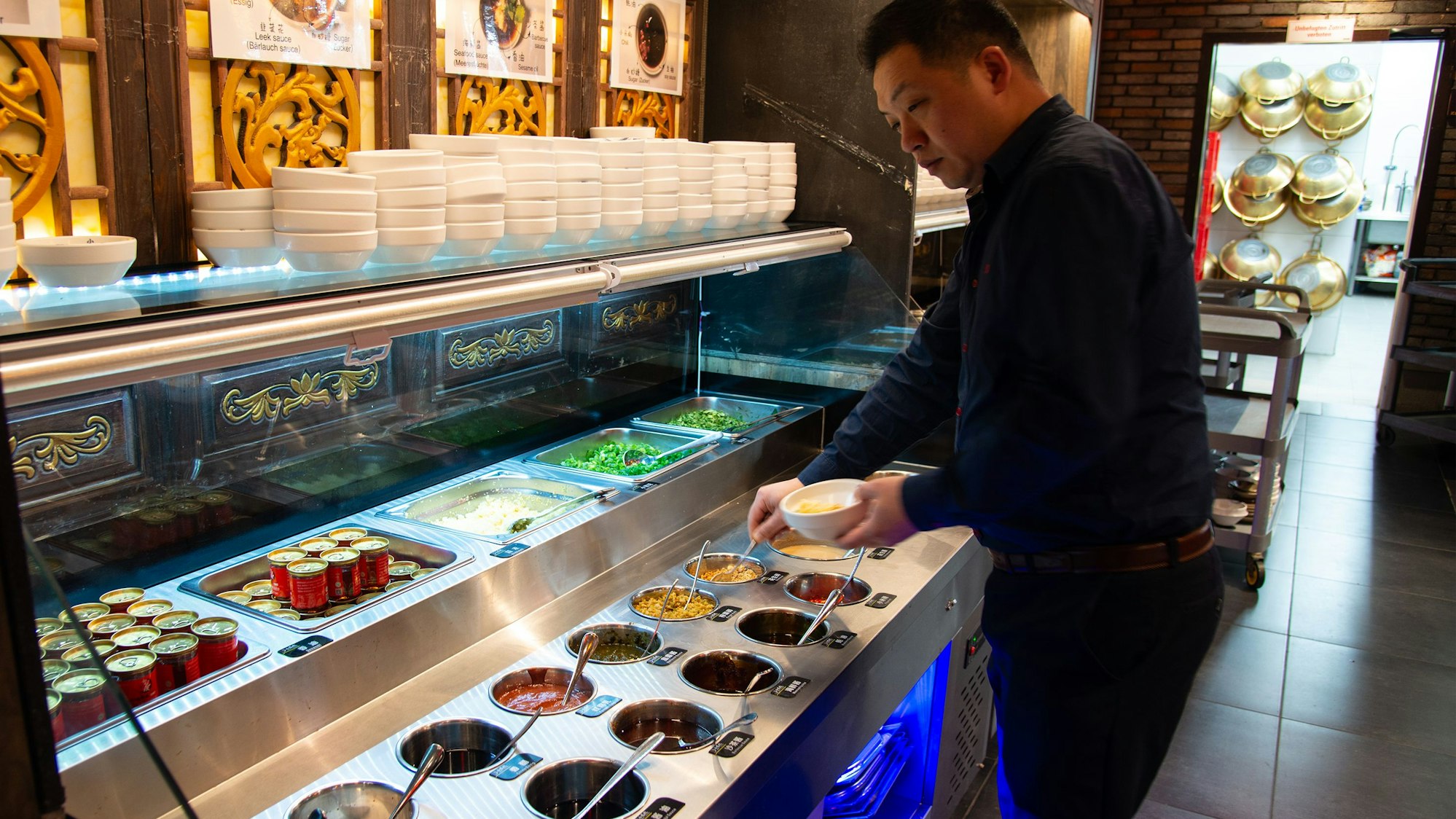 Jonatan Liu, der Chef des Xiao Long Kan an der großen Auswahl von Saucen.