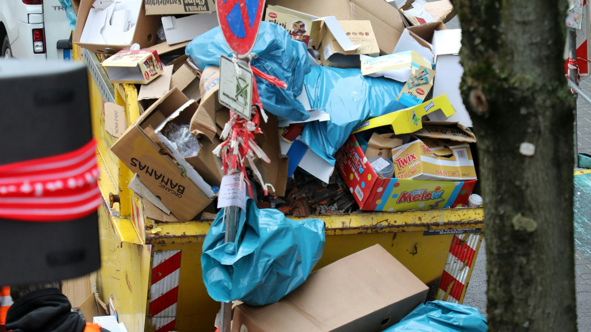 Ein mit Müll überfüllter Container am Straßenrand.