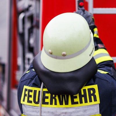 Ein Feuerwehrmann holt während einer Einsatzübung eine Leiter vom Dach eines Einsatzfahrzeugs.