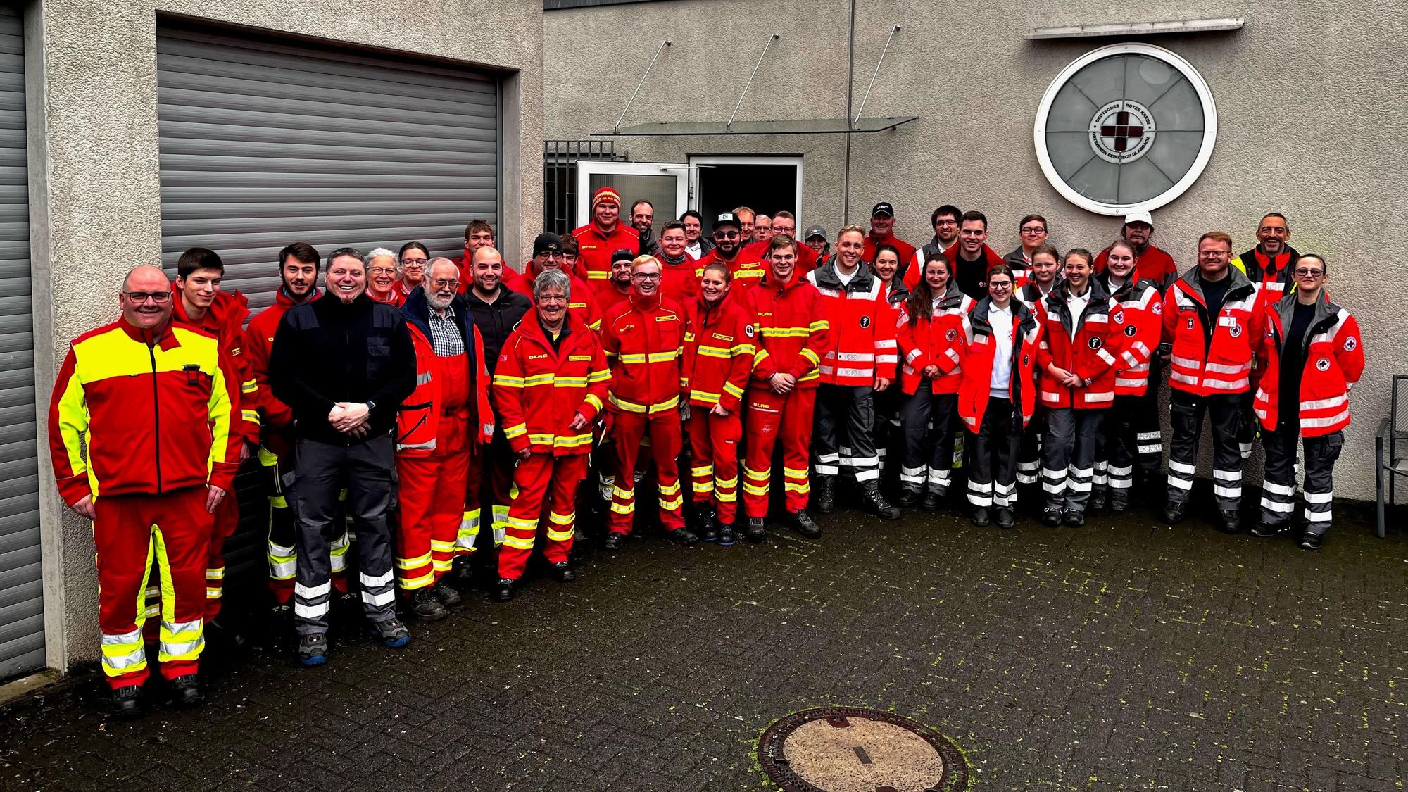 DRK-Einsatzkräfte stehen vor der DRK-Unterkunft des DRK-Ortsvereins Bergisch Gladbach an der Jakobstraße.