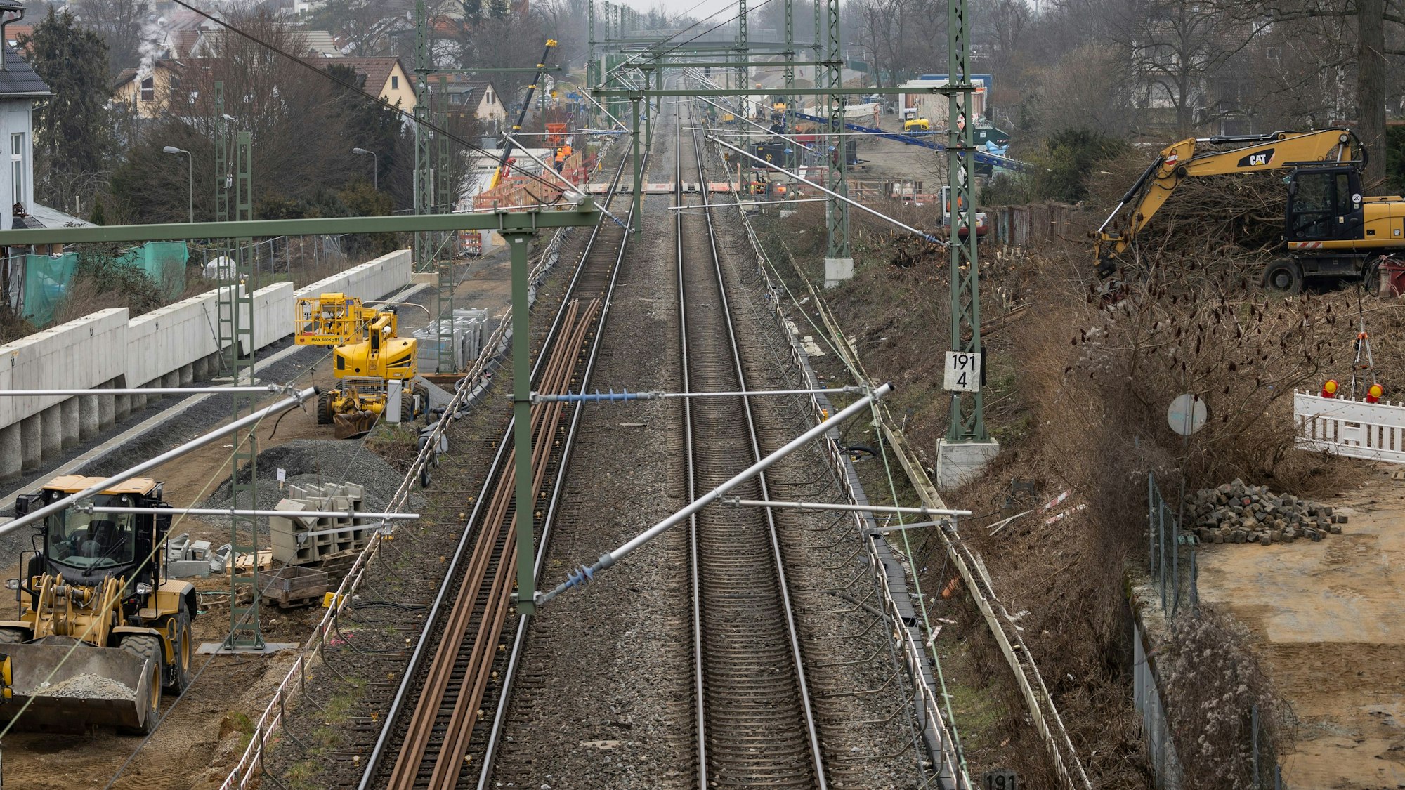 Man sieht eine Bahntrasse mit Baustellenfahrzeugen.