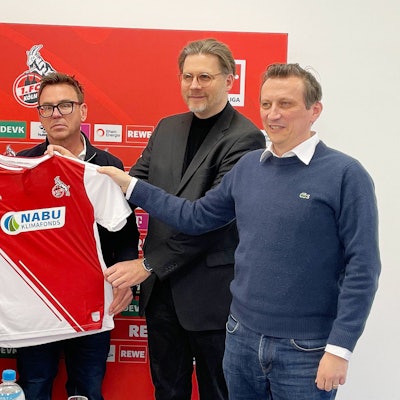 Steffen Baumgart, Markus Rejek, Nabu-Sprecher Roland Panter und Lionel Souque (v.l.) präsentieren das Trikot mit der Aufschrift Nabu.