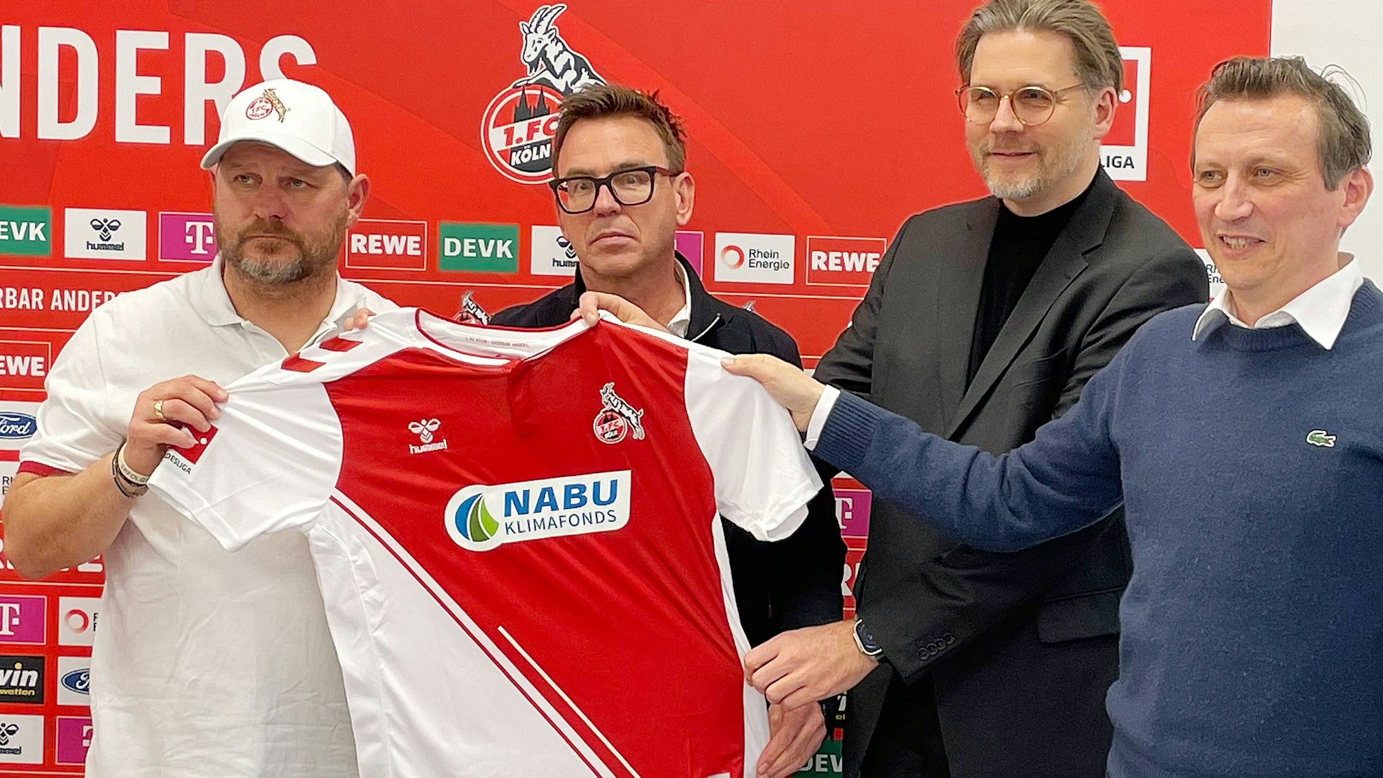 Steffen Baumgart, Markus Rejek, Nabu-Sprecher Roland Panter und Lionel Souque (v.l.) präsentieren das Trikot mit der Aufschrift Nabu.