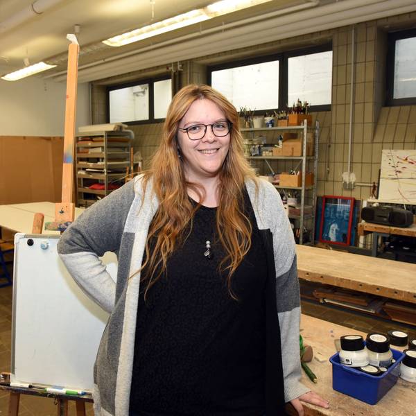 Ramona Gebel steht in einem Kunstraum, sie lächelt in die Kamera.