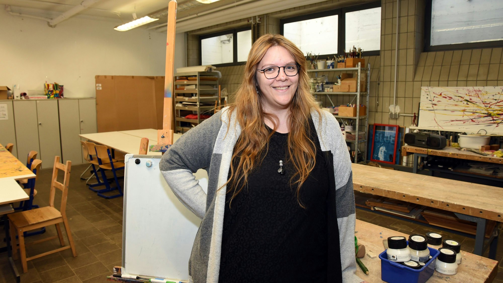 Ramona Gebel steht in einem Kunstraum, sie lächelt in die Kamera.