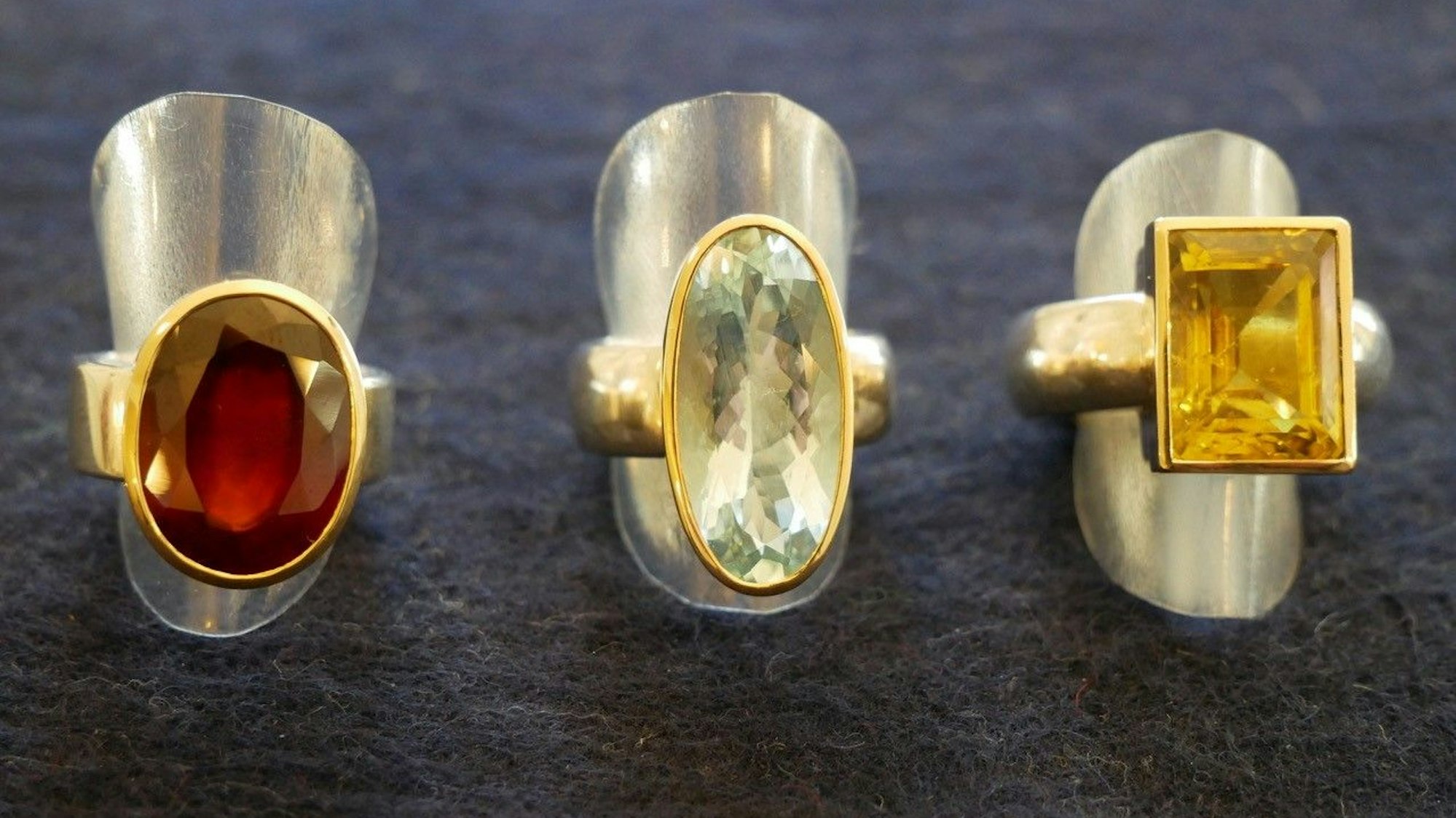 Ringe auf silbernen Metallkappen auf dunklem Stoffhintergrund