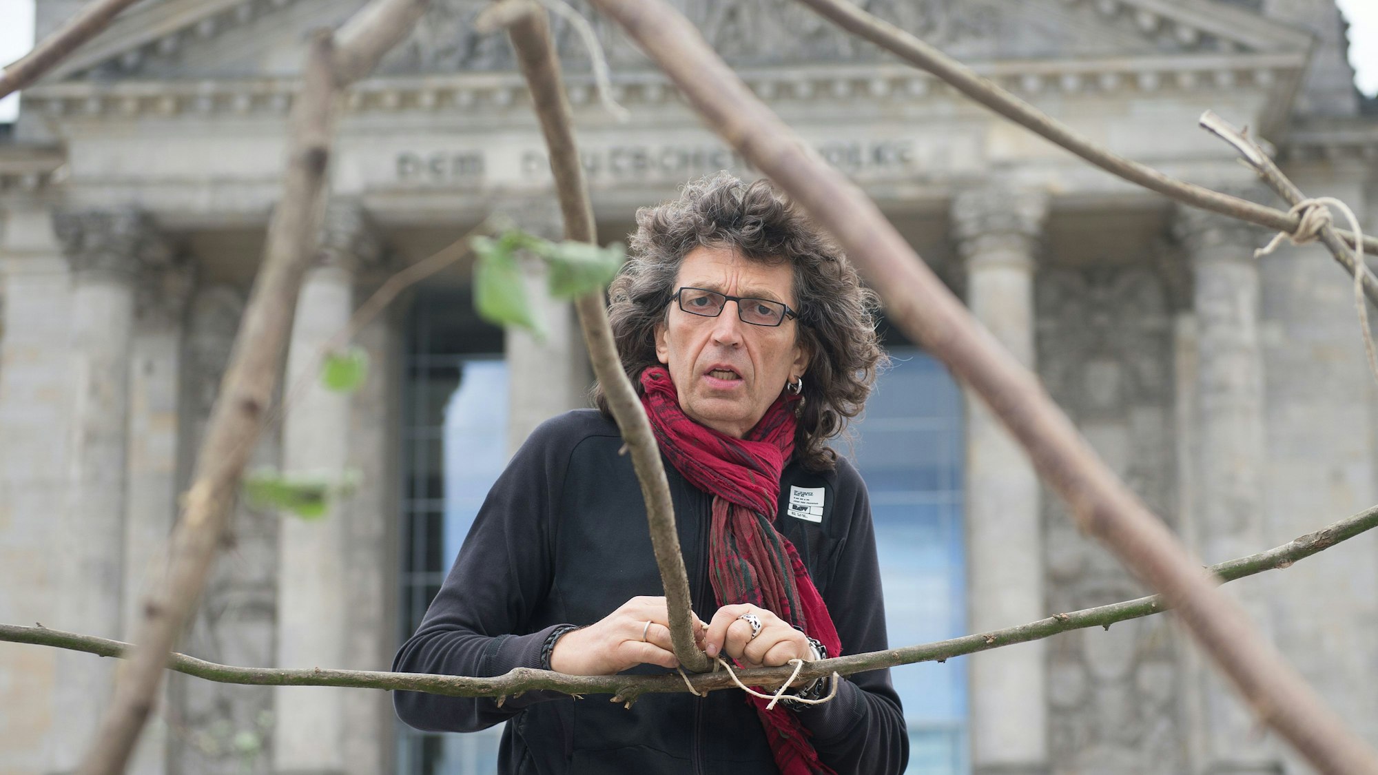 Der Künstler Hermann Josef Hack baut am 20.06.2014 vor dem Reichstagsgebäude in Berlin Notunterkünfte aus von ihm bemalten Lkw-Planen auf.