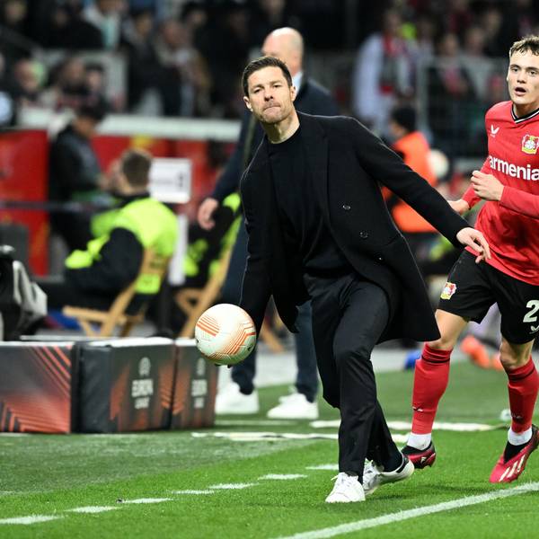 Leverkusens Trainer Xabier Alonso wirft neben Florian Wirtz einen Ball.