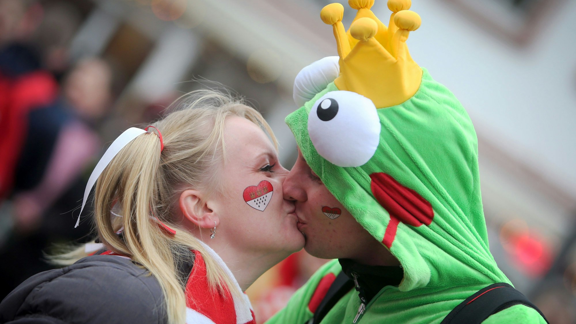 Eine Frau und ein Mann küssen sich in Karnevalskostümen.